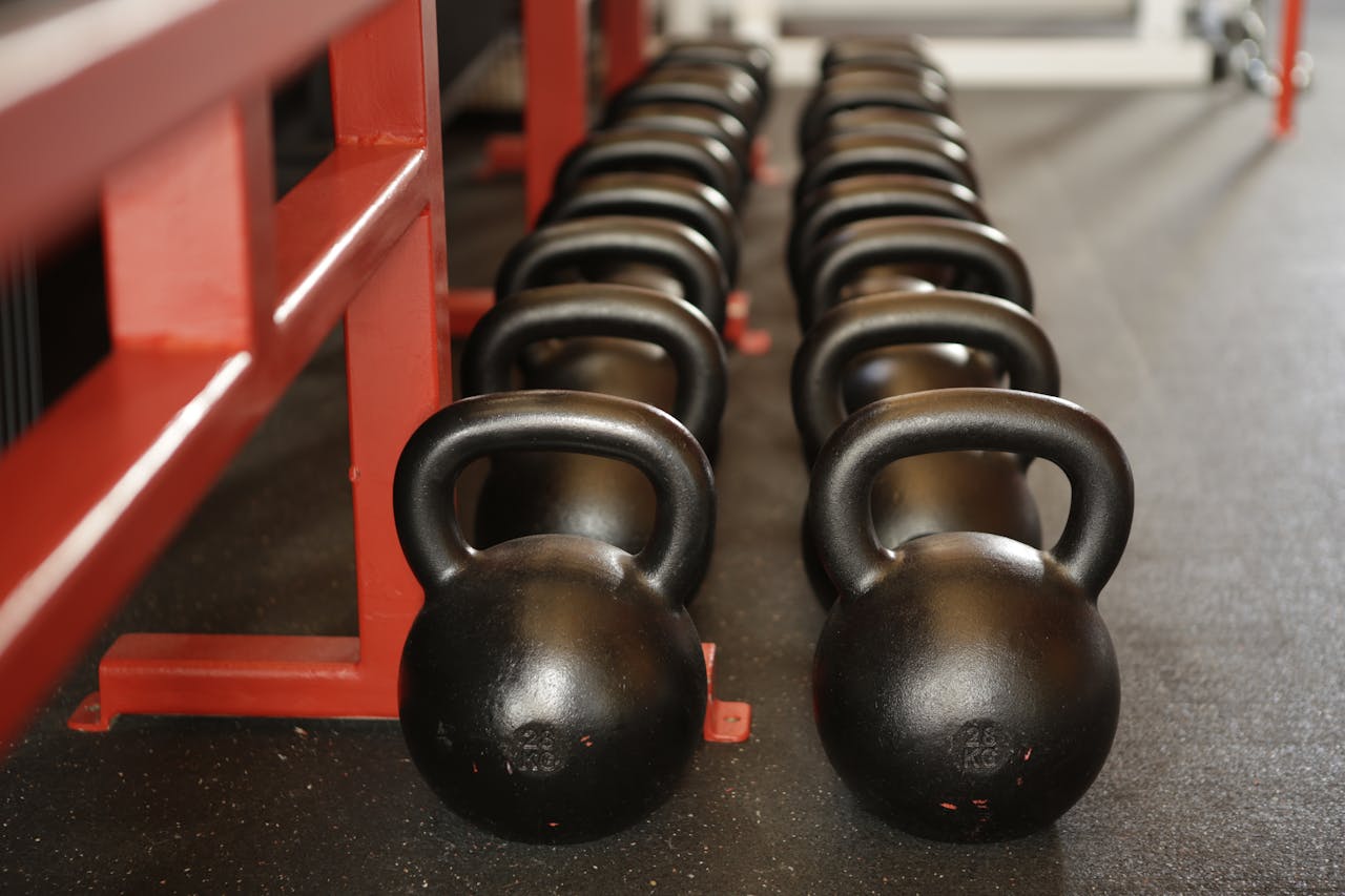 classes-02 Black kettlebells lined up in a gym, ready for fitness training.